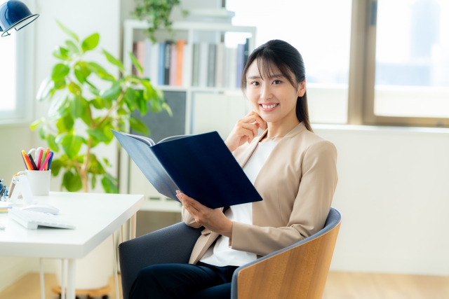 ノートを開き微笑む女性