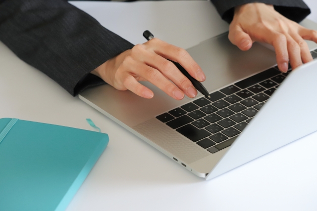 スーツの人がノートパソコンを触っている
