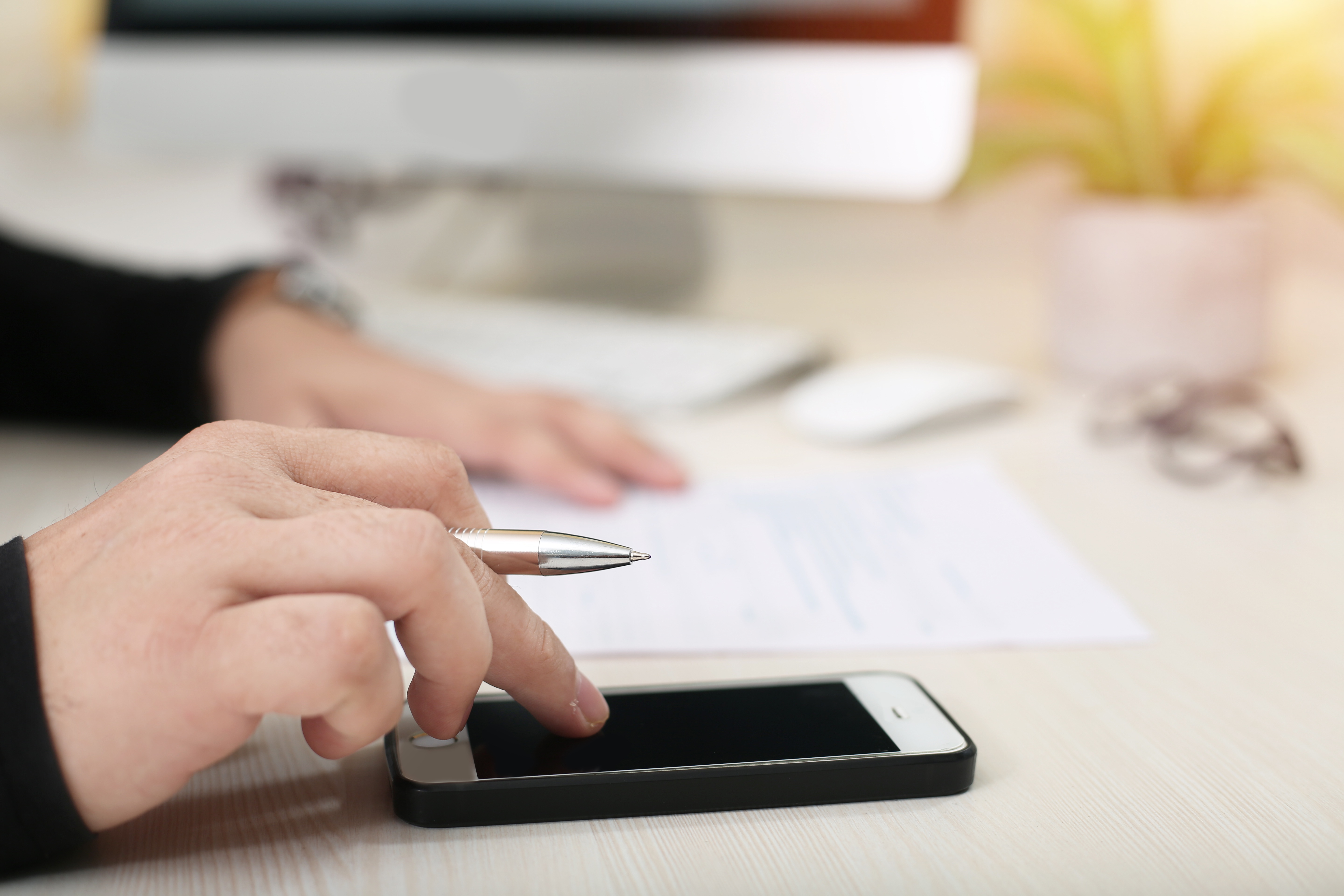 書類に書き込みながらスマホを触る手