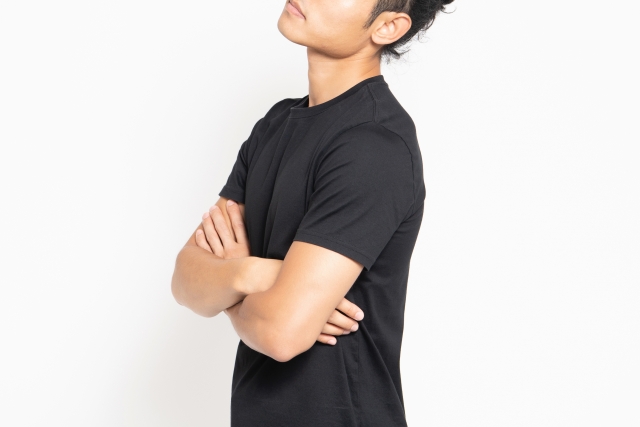 腕を組む黒いＴシャツの男性