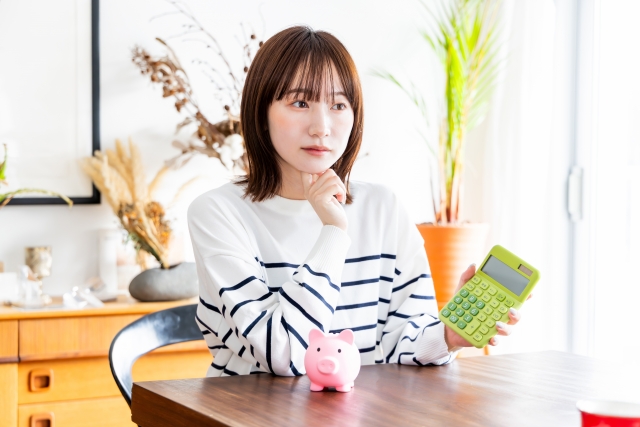 電卓を片手に悩む女性