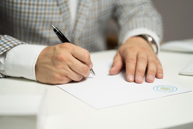 書類を作成する男性の手